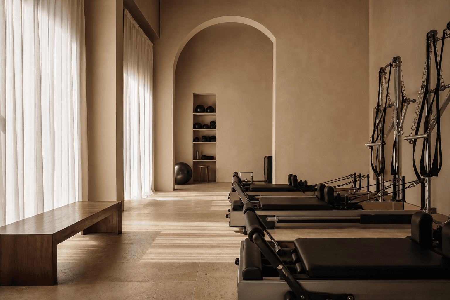 Warm sculptural resistance-training studio with limestone and linen